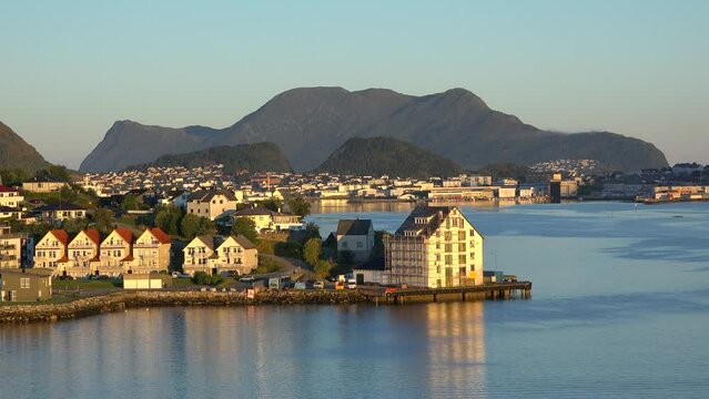 Norway. Wooden cottages on the beach. Buildings in the Norwegian fjords. Art style of architecture on a sunny day. Traditional Norwegian residential buildings with bright multi-colored facades