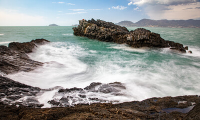 Waves flowing around the coastal sea rocks