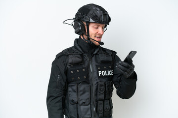 SWAT man over isolated white background keeping a conversation with the mobile phone