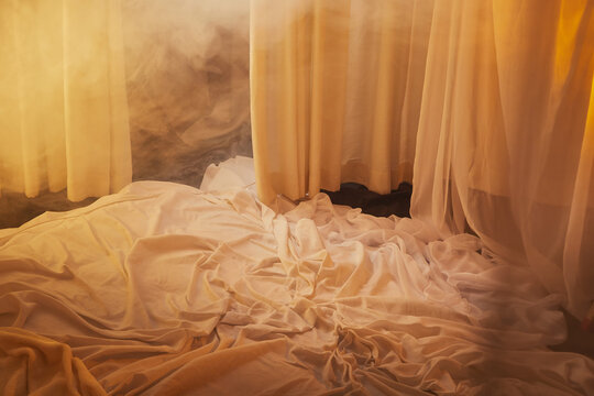 Light, soft transparent curtains in room. Canopy around bed with gentle light and blurring in evening. Boudoir. Concept of comfort in house and bedroom. Location and background for photo shoot