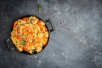 Uzbek pilaf in cast-iron pan. banner, menu, recipe place for text, top view