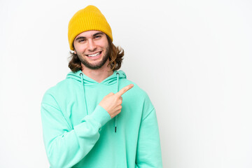 Young handsome man isolated on white chroma background pointing to the side to present a product