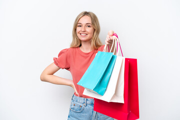 Young English woman isolated on white background holding shopping bags and giving them to someone