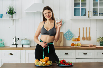attractive woman wear apron cook green salad in kitchen at home. Young beautiful girl feeling happy and enjoy eating vegetables healthy foods to diet and lose weight for health care in house.