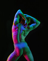 Portrait of graceful muscled male ballet dancer dancing over dark studio background with neon light. Art and beauty of male body - obrazy, fototapety, plakaty