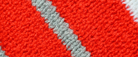 Handmade knitted fabric red and grey wool background texture