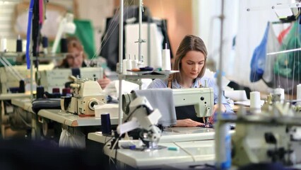 Female professional seamstress working fabric clothes industrial production electric sewing machine