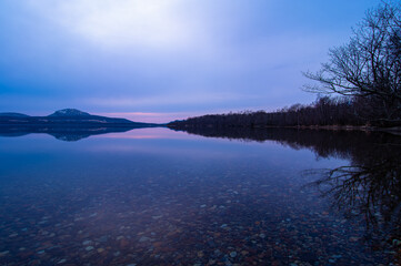夜明けの空を湖面に反射する湖。北海道の屈斜路湖。