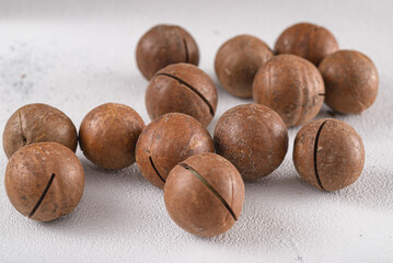 macadamia australian nuts scattered on white background