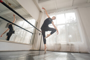 A beautiful Asian woman is dancing at the barre. Ballet dancer.