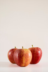 Three fresh red apples on a white background.
