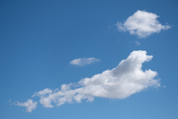 Landscape of fluffy and cottony white clouds on a blue sky.