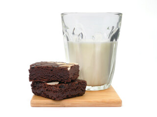 Brownies and milk glass on isolated white background. Chocolate brownie with sliced almond nuts toppings. Chocolate Brownie pieces. selective focus.