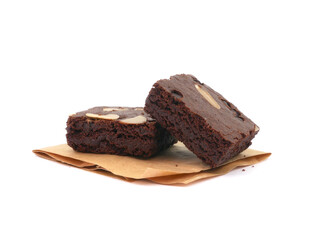 Brownies on paper isolated white background. Chocolate brownie with sliced almond nuts toppings. Chocolate Brownie pieces. selective focus.