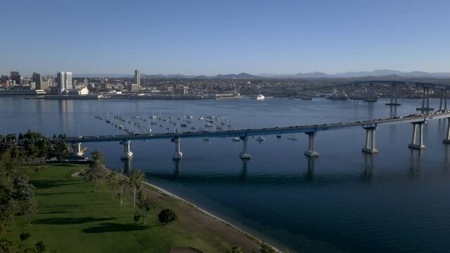 Drone shot over Coronado Bridge with harbor and skyline on a sunny day
