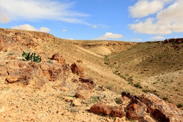 A Dry Stream Bed Between Two Hills In A Desert