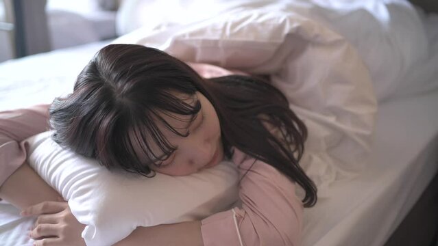 ベッドで眠るパジャマ姿の女性