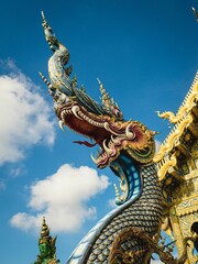 Fototapeta na wymiar Blue Dragon Naga Deity at Chiang Rai's Wat Rong Suea Ten (Blue Temple)