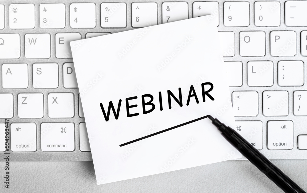 Poster white paper with text webinar lying on the keyboard