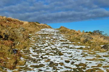 Fotobehang Picturesque winter scene featuring a snow-covered hill in Dartmoor National Park, UK © Artur Niedzwiedz/Wirestock Creators