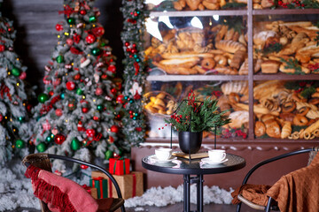 
A table for two, two chairs with blankets against the backdrop of a bakery in New Year's decorations