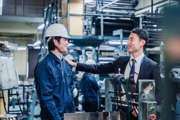 現場スタッフの肩を叩くオーナー