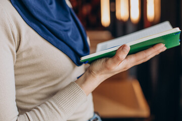 Muslim woman praying holding koran on ramadan