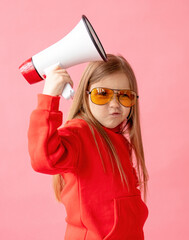 Portrait of a child girl screaming into a megaphone, color background