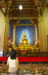 Female Visitor Making a Wish in the  Ordination Hall of Wat Benchamabophit (The Marble Temple), Bangkok, Thailand