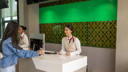 Young teenager traveler hands documents and passport to a female airline attendant for flight check in.