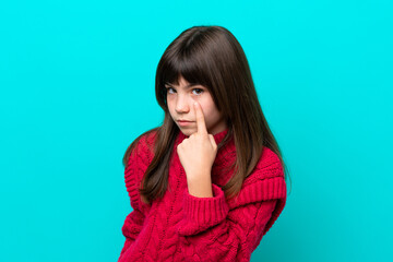 Little caucasian girl isolated on blue background showing something