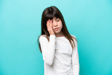 Little caucasian girl isolated on blue background with headache