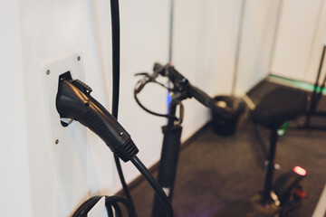 Battery charging process of gray electric stand-up scooter.