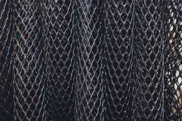 Black plastic polymer granules rolled into a tube close-up.