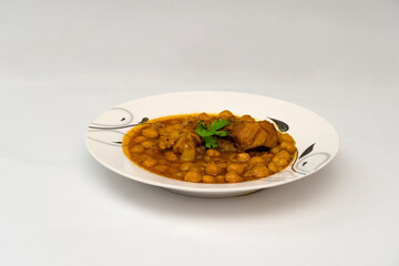 Chicken chana (Murgh chana) an indian street food made of chicken, chickpeas, tomatoes and cumin in plate on whtie background.                           