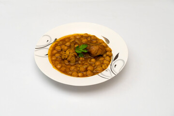 Chicken chana (Murgh chana) an indian street food made of chicken, chickpeas, tomatoes and cumin in plate on whtie background.                           