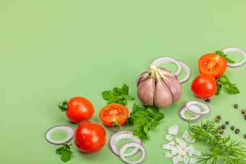 Culinary background with fresh vegetables and herbs. Tomatoes cherry, purple onion rings