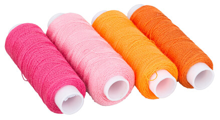 Spools with orange and pink thread for sewing, supply for sewing, isolated objects 
