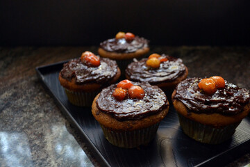 Vegan coffee cupcakes with chocolate frosting and acerola cherries