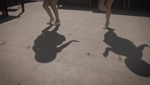 A close up footage of dancing Bolivian performers casting their shadows on the ground.