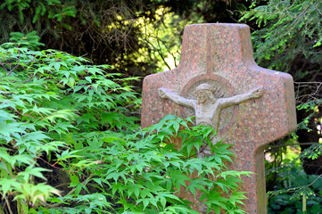 Grabstein mit Jesus Christus von grünen Blättern umgeben