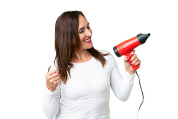Middle age woman holding a hairdryer over isolated chroma key background celebrating a victory