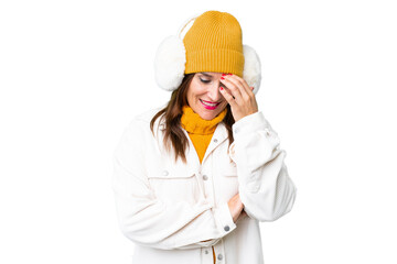Middle age woman wearing winter muffs over isolated chroma key background laughing