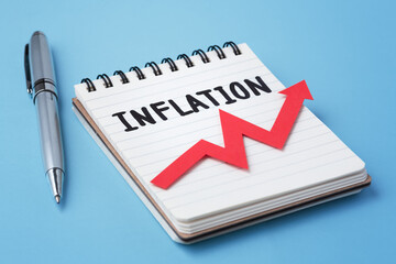 Inflation rate rising concept, inflation word on notebook and red graph going up