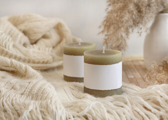 Fototapeta na wymiar Candles with label on cosy sweater near dry pampas grass, Close up, mock up