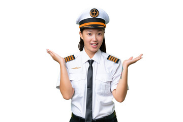 Airplane pilot Asian woman over isolated background with shocked facial expression