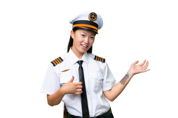 Airplane pilot Asian woman over isolated background making guitar gesture
