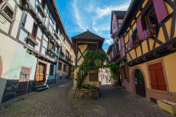 View of Rue du Rempart street in Eguisheim village, Alsace, France, Europe. Street with colorful houses. 