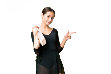 Young woman practicing ballet over isolated chroma key background pointing finger to the side