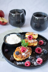 Delicious cheesecakes with berries and sour cream. Delicious breakfast. Morning